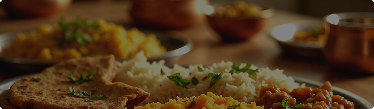 Authentic Indian food platter featuring rice, curry dishes, and freshly prepared flatbread