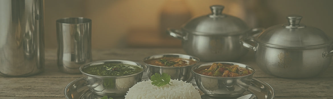 Traditional stainless steel cookware and Indian meal served with rice and curry dishes